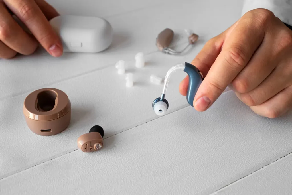 holding hearing aids راهنمای جامع تنظیم سمعک در منزل خطاهای رایج تنظیم سمعک در منزل