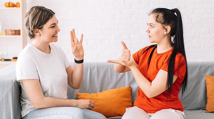 young girl learning sign language سمعک و زبان اشاره: مکمل یا جایگزین؟ راهنمای انتخاب بهترین روش ارتباطی استفاده همزمان از سمعک و زبان اشاره